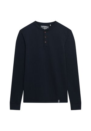 Granatowa koszula henley z długim rękawem, wykonana z miękkiej bawełny, z trzema brązowymi guzikami przy kołnierzyku i małą metką z logo na dole.