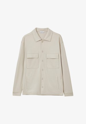 Giacca beige a maniche lunghe in tessuto morbido, con colletto aperto, chiusura con bottoni, due tasche sul petto e dettagli sui fianchi.