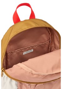 Backpack with a yellow-brown exterior and red top handle; interior features a smooth pink lining and a pocket labeled "LIEWOOD."