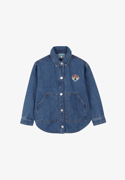 Veste en denim bleu moyen avec un devant à boutons, deux grandes poches avant et un patch brodé coloré sur la poitrine.