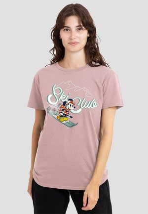 Light pink cotton t-shirt featuring a graphic of a cartoon character on a snowboard with "Ski Club" text and mountain outline.