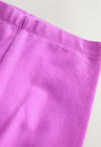 Fuchsia bomulls tyg med en slät textur, utrustad med en sydd elastisk midjeresår och utan synliga mönster eller hårdvarudetaljer.