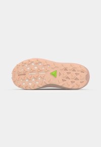 Suela de zapato con una superficie de goma rosa texturizada, que presenta un acento triangular verde y varios dibujos de tracción en forma de triángulo.