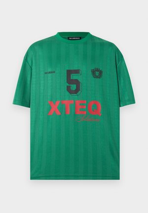Πράσινη αθλητική φανέλα με κοντό μανίκι, μαύρος αριθμός 5, έμβλημα στο στήθος και κόκκινο λογότυπο "XTEQ Solutions" στην μπροστινή πλευρά.