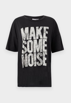 Μαύρο βαμβακερό t-shirt με κοντά μανίκια, που φέρει μεγάλο, φθαρμένο λευκό κείμενο με την επιγραφή "ΚΑΝΕ ΛΙΓΟ ΘΟΡΥΒΟ" στο μπροστινό μέρος.