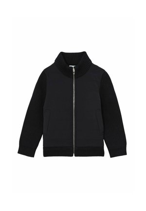 Musta takki, jossa on korkea ribattukolttu, pehmustettu vartalo ja ribatukset hihat. Varustettu etuvetoketjulla ja kahdella sivutaskulla. Kankaan pinta on teksturoitu.