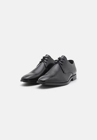 Pantofi negri din piele, cu bot ascuțit, șiret plat, toc jos și suprafață netedă. Design simplu, fără modele sau accente vizibile.