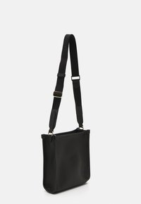 Borsa a spalla in pelle nera con finitura testurizzata, dotata di una lunga tracolla regolabile e accessori in tono oro. Design rettangolare semplice.