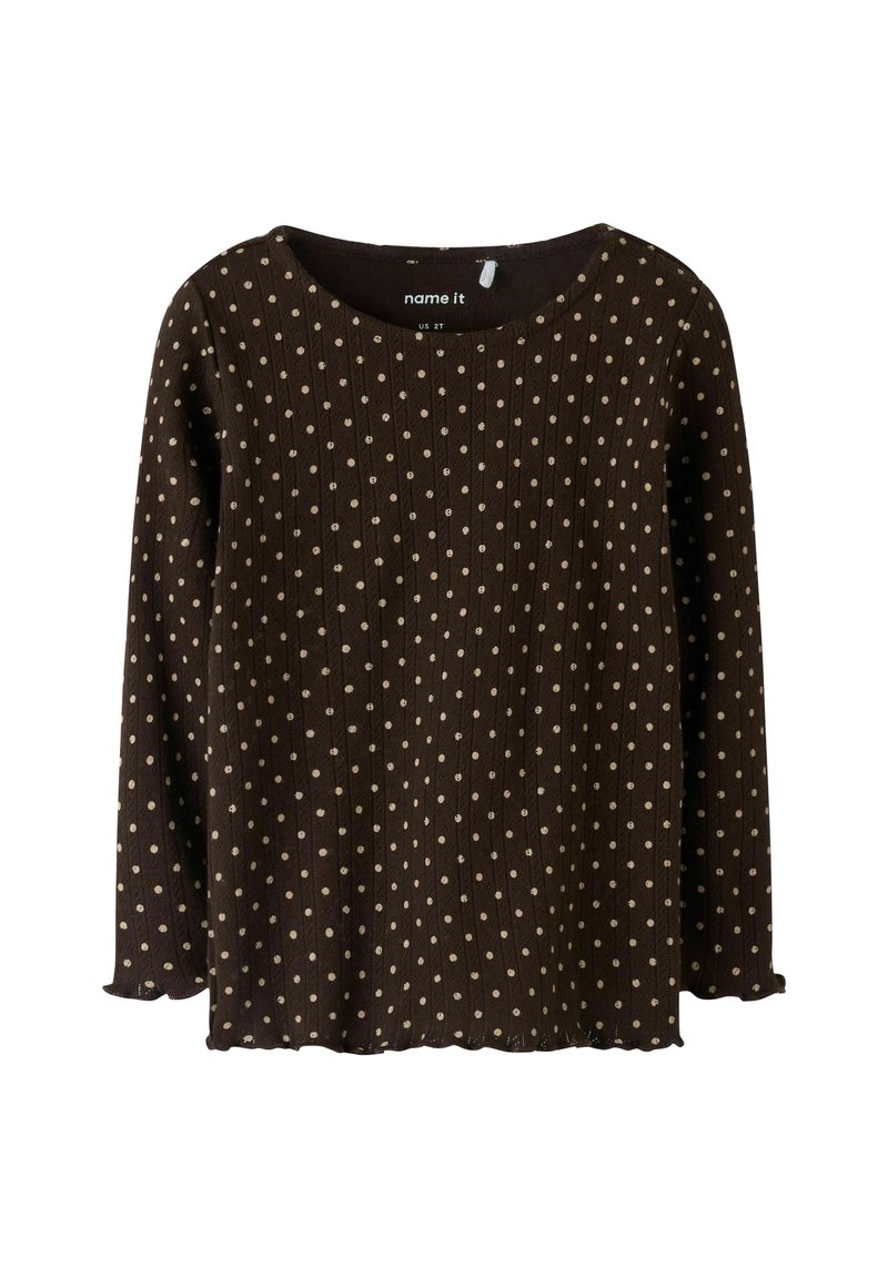 Bruine top met lange mouwen, voorzien van een ribbelstructuur en verspreide lichtbruine polkadots. Ronde halslijn en gebogen zoomdetail.