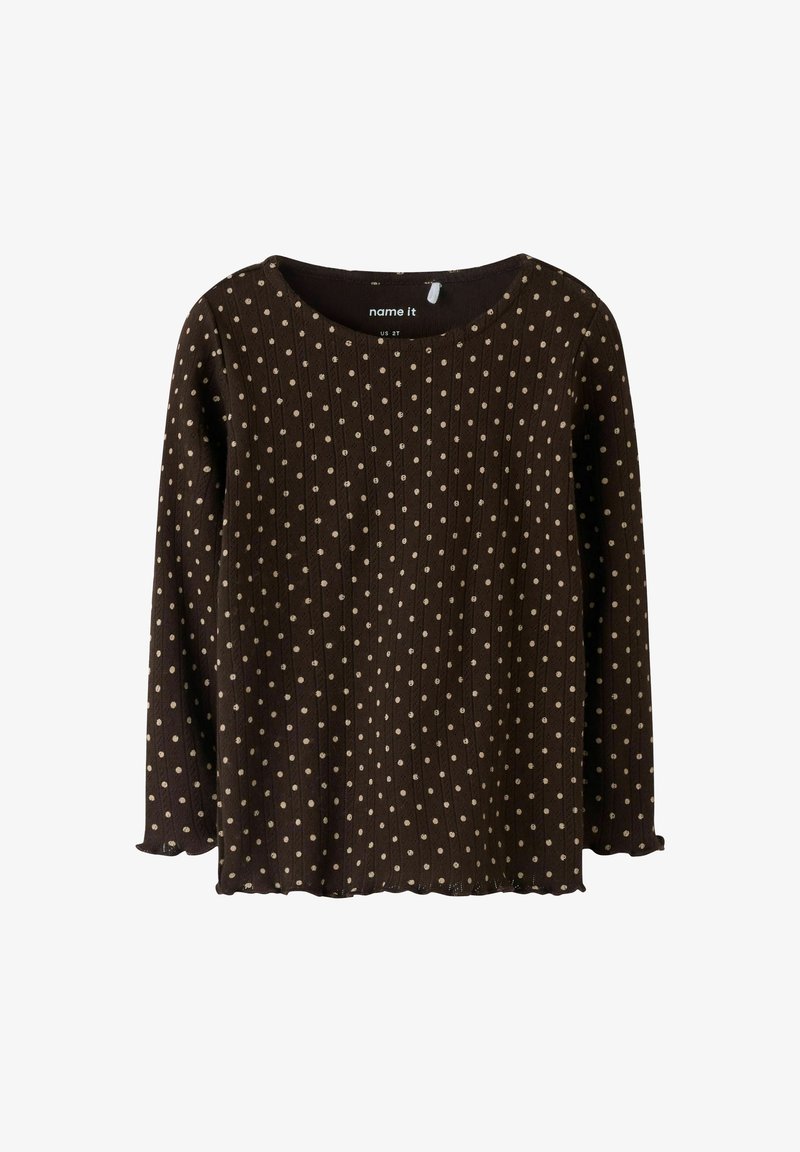 Bruine top met lange mouwen, voorzien van een ribbelstructuur en verspreide lichtbruine polkadots. Ronde halslijn en gebogen zoomdetail.