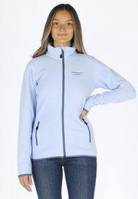 Hellblaue Fleecejacke mit hohem Kragen, kontrastierenden marineblauen Reißverschlüssen und seitlichen Reißverschlusstaschen. Das Material scheint weich mit einer glatten Textur zu sein.