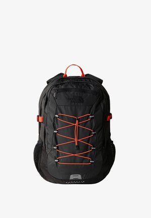Schwarzer Rucksack mit orangefarbenen Akzenten. Verfügt über ein vorderes Bungee-Seilsystem, mehrere Fächer, gepolsterte Rückseite und Netztaschen an den Seiten.