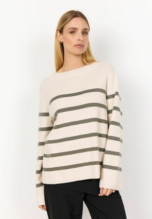 Beige striped sweater featuring horizontal olive green stripes, wide neckline, long sleeves, and ribbed texture. Worn with dark pants.