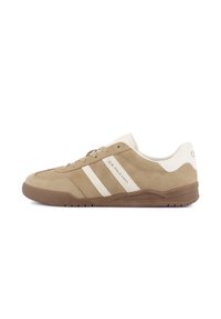 Basket en daim brun clair avec des bandes blanches et un bout de talon blanc, semelle plate, et marquage "U.S. Polo Assn." sur le côté.