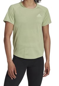 Jasnozielona sportowa koszulka wykonana z oddychającej tkaniny, z okrągłym dekoltem, krótkimi rękawami i subtelnym teksturowanym wzorem z logo Adidas.