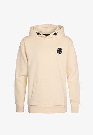 Beige Kapuzenpullover mit Fronttasche und schwarzem Logo-Patch, kombiniert mit blauen Jeans und weißen Sneakers. Heller Hintergrund.