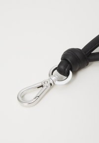 Black leather strap with a silver metal clasp, featuring a smooth texture and a round attachment ring near the knot.