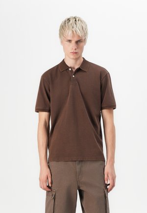 Brown polo shirt made of cotton fabric, featuring a classic collar, two-button placket, and short sleeves, paired with brown cargo pants.