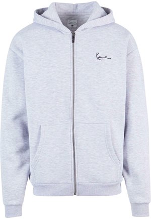Svetlo siva zip-up kapuća napravljena od mekanog materijala. Ima opušten kroj, dva prednja dzepa i izvezeni logo na grudima.