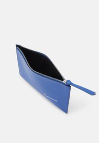 Niebieska skórzana sakiewka z zamkiem błyskawicznym, o płaskim designie i gładkiej fakturze. Posiada czarne wnętrze i białe detale tekstowe po jednej stronie.