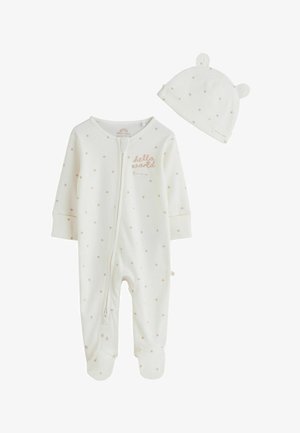 Baltas kūdikių smėlinukas su smulkia beige žvaigždžių raštu ir priekyje esančiu užtrauktuku, derantis su kepurėle su meškiuko ausytėmis ir žvaigždžių raštu.