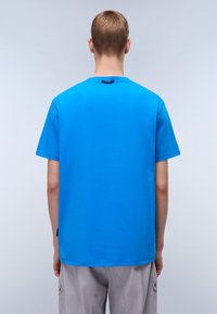 Modrá tričko s krátkým rukávem vyrobené z bavlny, s kulatým výstřihem a rovnými lemy. Jemná cedulka na výstřihu, jednoduchý design, bez vzorů.