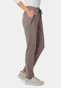 Graue Jogginghosen mit elastischem Bund, Kordelzug und seitlichen Taschen. Glattes Material, schmaler Schnitt, mit kontrastierenden schwarzen Seitennaht-Details.