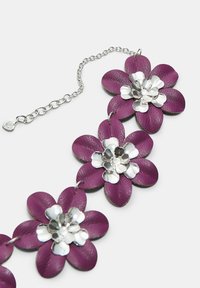 Necklace od ljubičaste kože s cvjetnim motivima, metalik srebrnim detaljima i kopčanjem od lančića, s izražajnim cvjetnim oblicima i glatkom teksturom.