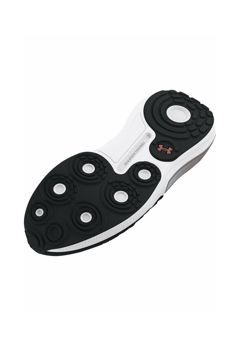 La semelle d'une chaussure de sport noir et blanc présente des motifs en caoutchouc circulaires, une texture durable et un petit logo près du talon pour une meilleure adhérence.