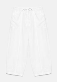 Pantalon blanc coupe ample avec taille élastique, cordon et deux poches plaquées à l'avant, présenté sur un fond uni.