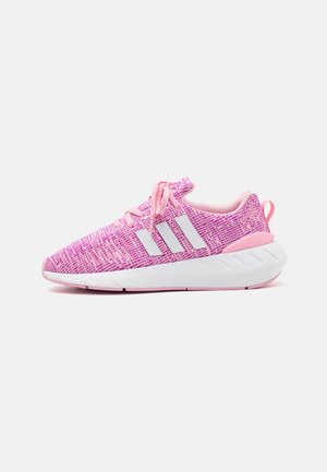 Sportssko med strikket overdel i pink nuancer, hvide striber, runde snørebånd og en hvid gummisål med teksturerede detaljer.