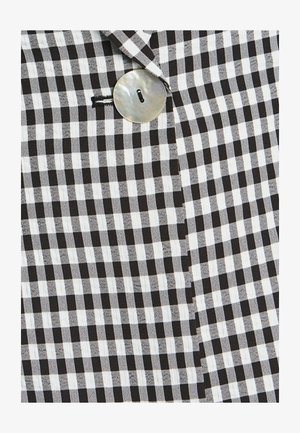 Mustvalge ruuduline kangas silmapaistva nupuga, näidates sujuvat tekstuuri ja geomeetrilist mustrit. Omab klassikalist disaini.