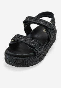 Sandalias de plataforma negras con correas texturizadas, cierres ajustables y una base ancha. Fabricadas en material sintético con una plantilla suave.