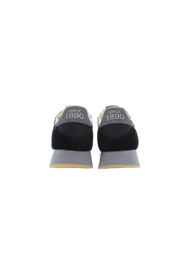 Czarno-szare buty sportowe z textured górą, żółtymi akcentami, wyściełanym kołnierzem i napisem "SINCE 1890" na pięcie. Gumowa podeszwa.