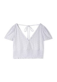 Blusa bianca cropped con scollatura a V profonda, maniche a palloncino e orlo arricciato. Realizzata in tessuto testurizzato con un motivo a losanga ripetuto.