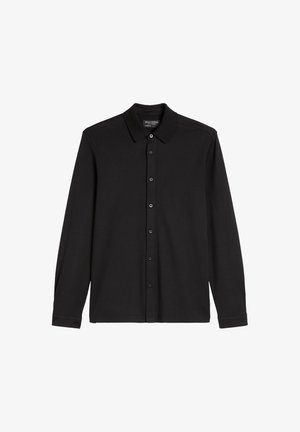 Camicetta nera a maniche lunghe, realizzata in morbido materiale, con colletto, chiusura frontale a bottoni e senza motivi o decorazioni.