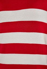 T-shirt a righe rosse e bianche realizzato in tessuto liscio ed elastico; presenta ampie righe orizzontali con spaziatura uniforme e una vestibilità classica.