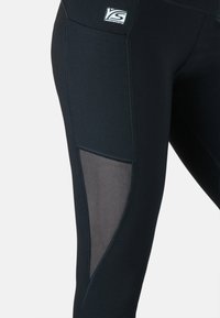 Schwarze Sportleggings mit enganliegendem Schnitt, ausgestattet mit Netzeinsätzen an den Seiten und kontrastierenden Nähten. Logo am Hüftbund. Glatte Textur.