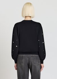 Schwarzer Sweatshirt mit einzigartigen Cut-out-Details an den Ärmeln, Rippbündchen und Saum. Weiche Stofftextur, lässige Passform.