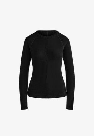 Chemise noire à manches longues en tissu doux, avec un col rond, des manches raglan et des coutures contrastées le long des coutures.