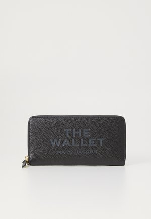 Must hiri rahakott, millel on tekstureeritud pind. Esiküljel on reljeefne bränding "THE WALLET MARC JACOBS" ning see on tõmblukuga sulguv.