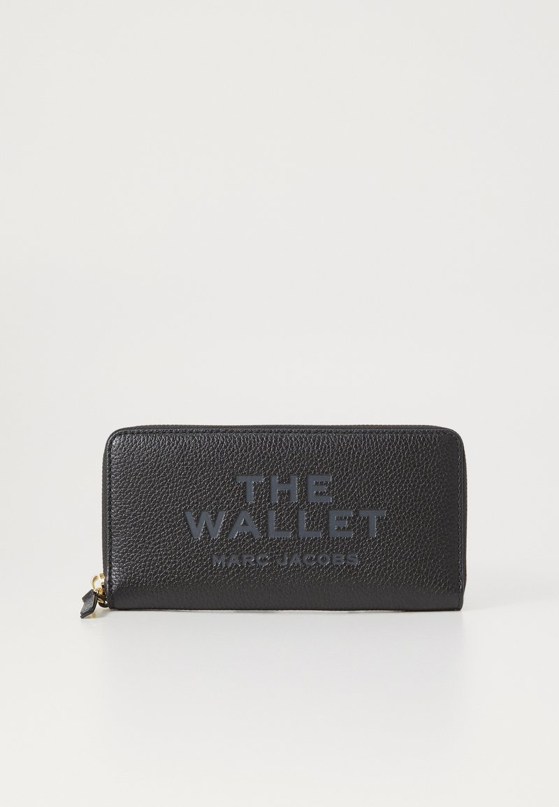 Juodas odinis piniginė su tekstūruota paviršiumi. Priekyje yra reljefinis prekės ženklas "THE WALLET MARC JACOBS" ir užtrauktuko uždarymas.