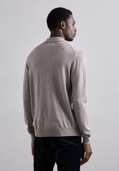 Hellgrauer Pullover mit Kragen, langen Ärmeln und gerippten Bündchen und Saum. Glatte Textur, minimales Design, dezente Farbe.