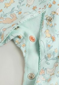 Body menthe à manches courtes avec imprimé floral et animal ; doté de pressions métalliques et en plastique au niveau de l'encolure. Tissu en coton doux.