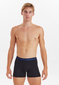 Black cotton boxer briefs with a blue waistband labeled "JBS Underwear," featuring a snug fit and a smooth texture.