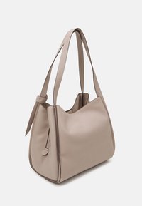 Beige leren hobo tas met een gestructureerd oppervlak, twee lange banden en een ritsdetail aan de zijkant. Zachte, ronde silhoutte.