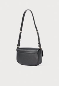 Black leather crossbody bag with a rounded bottom, flap closure, and adjustable strap with gold-tone hardware on a white background.