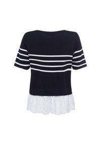Navyblauwe cropped top met witte horizontale strepen en een witte kanthem die uitsnijdingen en gegolfde randen heeft.