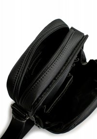 Schwarze Nylon-Crossbody-Tasche mit mehreren Reißverschlussfächern, verstellbarem Schulterriemen und verstärkten Nähten.