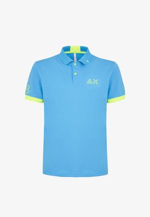 Polo in cotone azzurro chiaro con colletto e maniche verdi. Presenta il logo sul petto e una grafica con il numero sulla manica. Vestibilità classica.